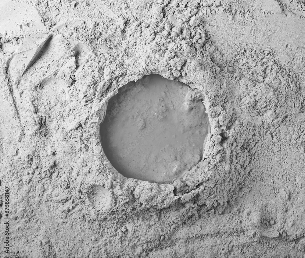 Dry cement, plaster powder with round concrete binder puddle background