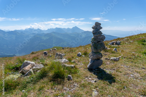 Tall pile of stones on the top of the "red peaks trail" during sunny summer day in Polish Tatra mountains.