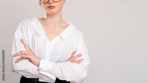 Confident business woman. Successful career. Portrait of ambitious female leader in white shirt standing with crossed arms isolated on light empty space background. Feminist rights.