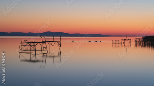 quite morning sunrise at lake balaton in hungary no waves. reflection of the sky