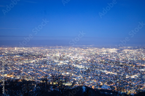 View from top of Mt. Moiwa in Sapporo city  Hokkaido  Japan during winter with night cityscape blur background.