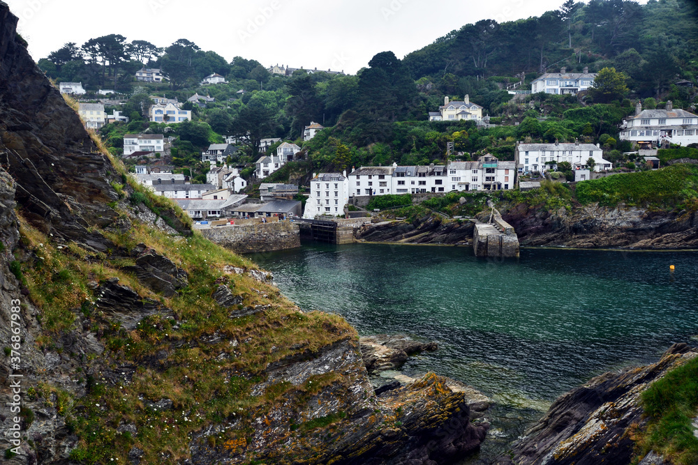 View of the entrance to Polperro harbour and white cottages of the village, Cornwall, England, UK