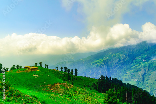 View of abandoned Hut made of stones   mud with cloudy blue sky background during sunset enroute to Prashar Lake trekking trail from Baggi village  Mandi  Kullu Manali region  Himachal Pradesh  India.