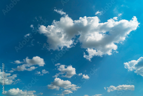 Picturesque white clouds illuminated by sunlight on a blue sky.