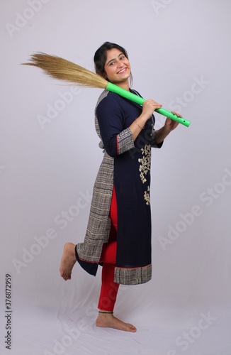 Young asian woman of indian origin with a sweeping broom © Ojas