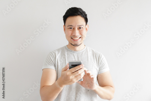 Asian man is feeling happy with the application in the smartphone. © Sevendeman