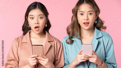 Portrait of two beautiful women friends posing happy gesture