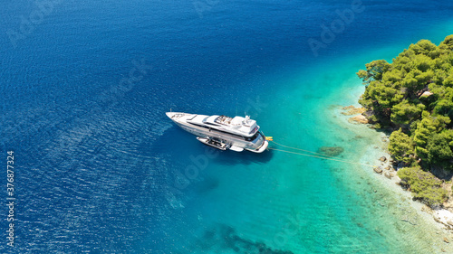 Fototapeta Naklejka Na Ścianę i Meble -  Aerial drone photo of yacht anchored in famous crystal clear bay and turquoise beach of Panormos, Skopelos island, Sporades, Greece