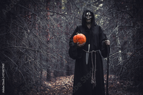 Foto Woman devil ghost demon costume horror and scary she holding pumpkin in hand in the forest