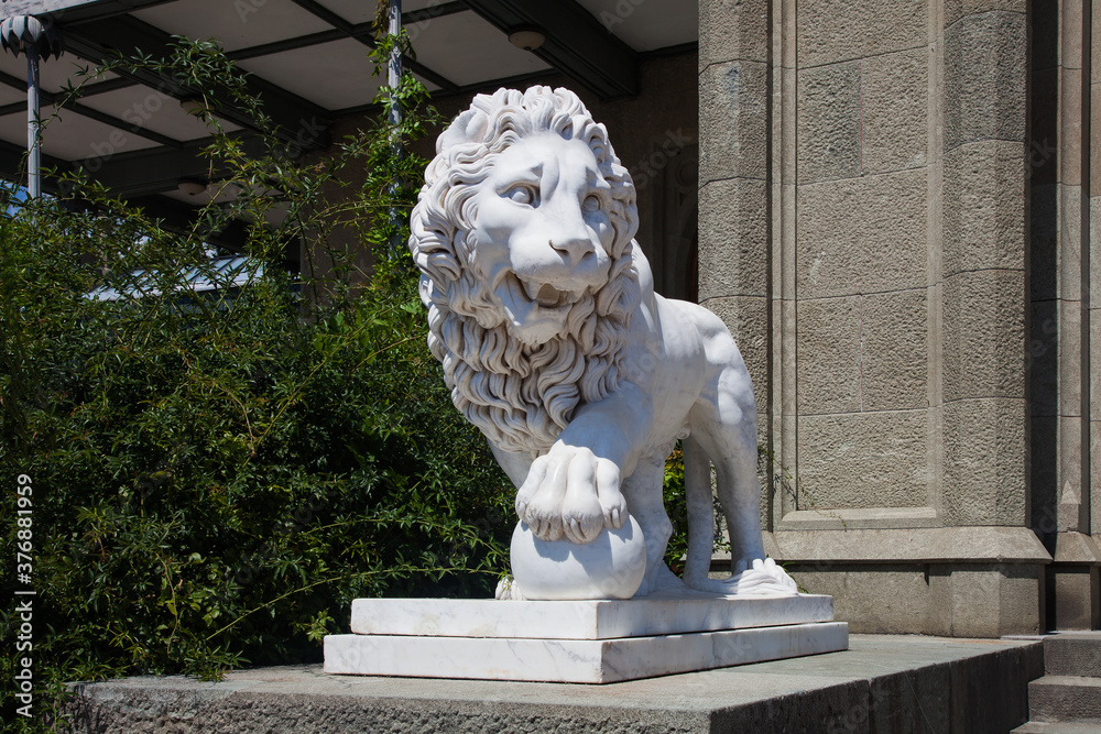 ALUPKA, CRIMEA - August 03, 2020: Marble statue of a lion with a paw on a ball