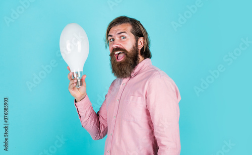 man just inspired. economy of electricity. bright minded hipster. creative inspiration. light your way. bearded man with bulb. smiling man hold big lamp. got new idea. concept of creativity