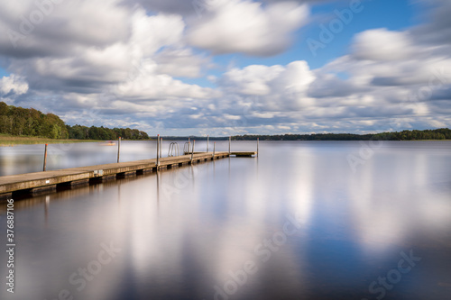 Long exposure over jetty and lake with clouds and reflection. Location is Vastersjon, Sweden.