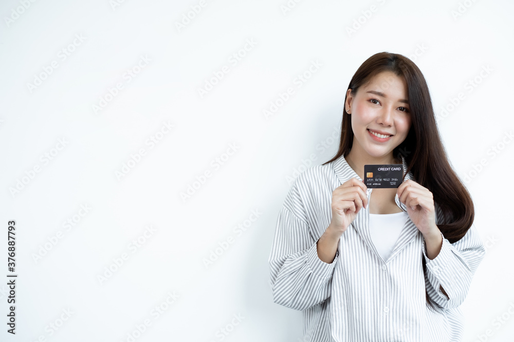 The hand of an Asian woman holding a credit card is used for online shopping and Internet payments The hand of an Asian woman holding a credit card is used for online shopping and Internet payments
