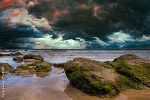 Stones and cloudy dramatic sky in sea