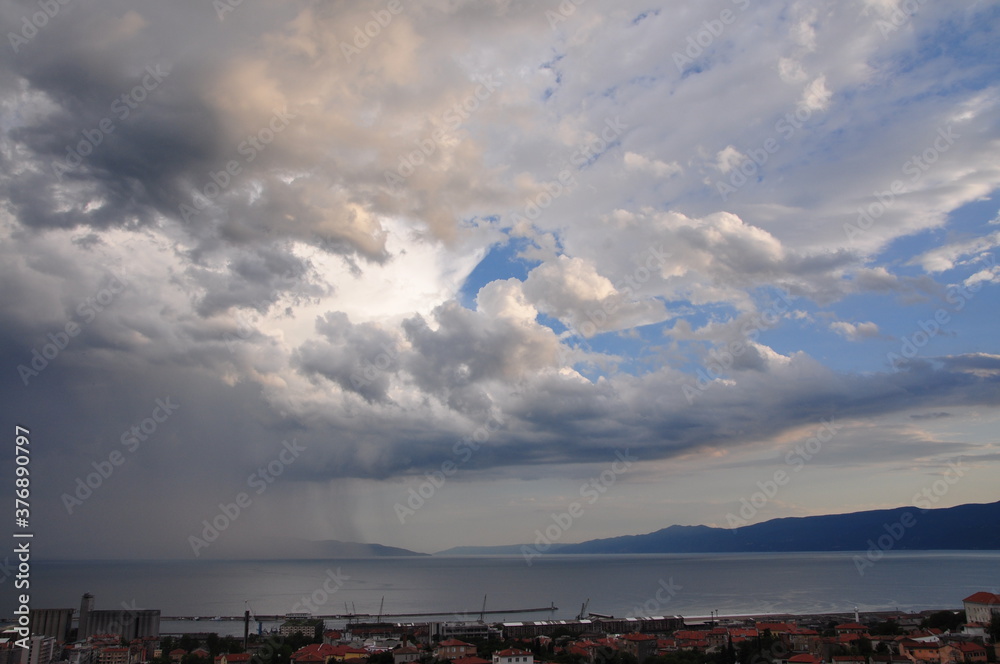 clouds and rain curtain over the Adriatic Sea defront Rijeka city, Croatia