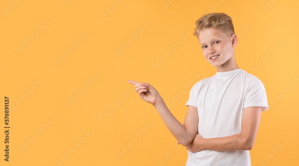Happy boy pointing finger aside at copy space Happy boy pointing finger aside at copy space