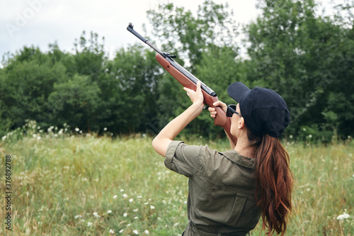 Woman woman holding a gun up hunting aiming fresh air green 