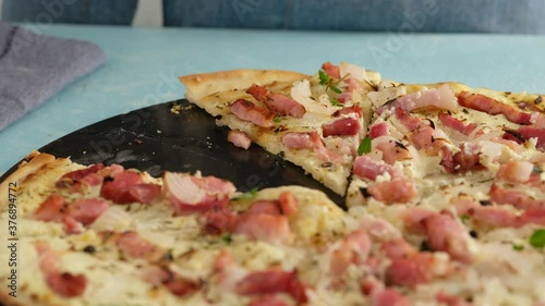 Pie with bacon, onion and sour cream. Flammkuchen. The woman made a German pie. Pizza.