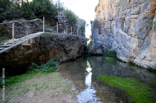 Nice corner of the natural path of the guadalaviar in San Blas, Teruel, with a metal walkway that crosses the river photo