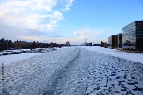 Copenhagen frozen river and city in winter with snow.