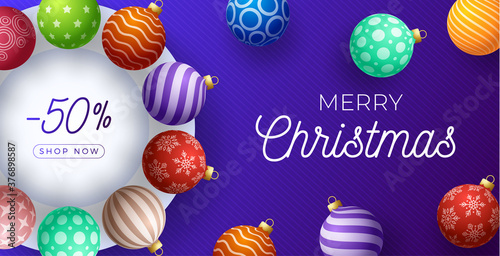 Christmas horizontal sale promo banner. Holiday vector illustration with realistic ornate colorful Christmas balls on purple background.