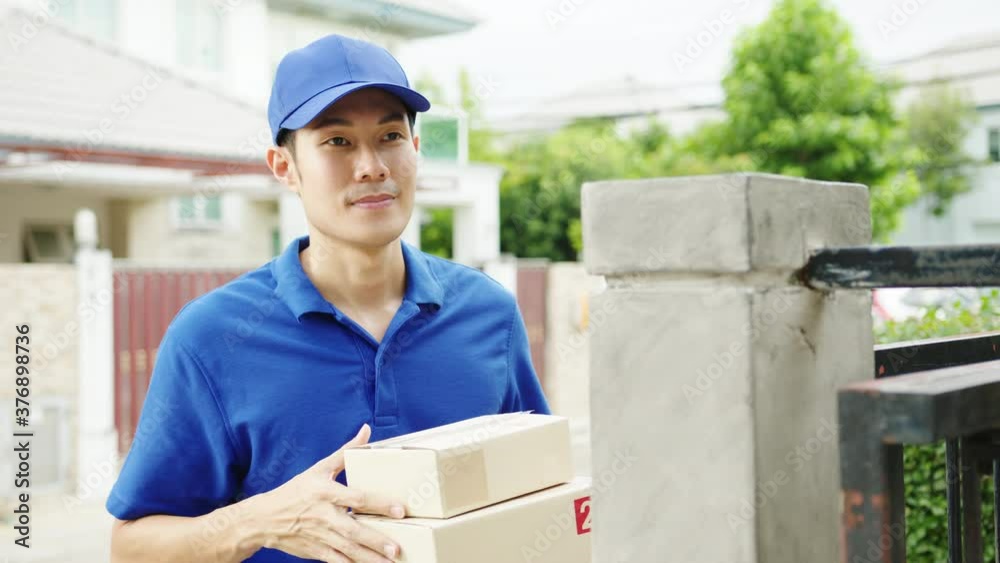 Young Asia postal delivery courier man in blue shirt handling parcel boxes for sending to customer at house and Asian female receive delivered package outdoors. Package shopping food delivery concept. Young Asia postal delivery courier man in blue shirt handling parcel boxes for sending to customer at house and Asian female receive delivered package outdoors. Package shopping food delivery concept.