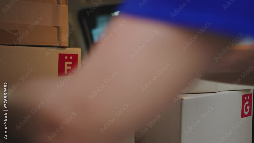 Young Asia volunteer delivery man in uniform wearing face mask deliver parcel paper box package in car at front house. Package shopping food delivery, lifestyle new normal after corona virus concept.