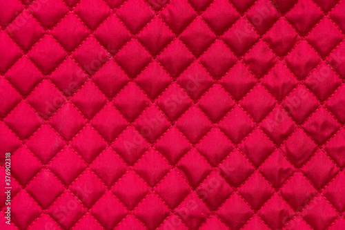 red stitched quilted bag cloth background close up photo