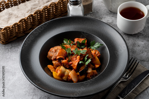Traditional german veal ragout with big potato chunks on a grey background,?menu photography