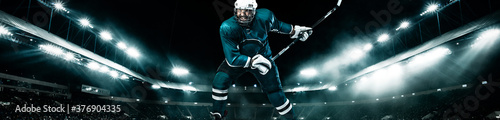 Photography Ice Hockey player athlete in the helmet and gloves on stadium with stick