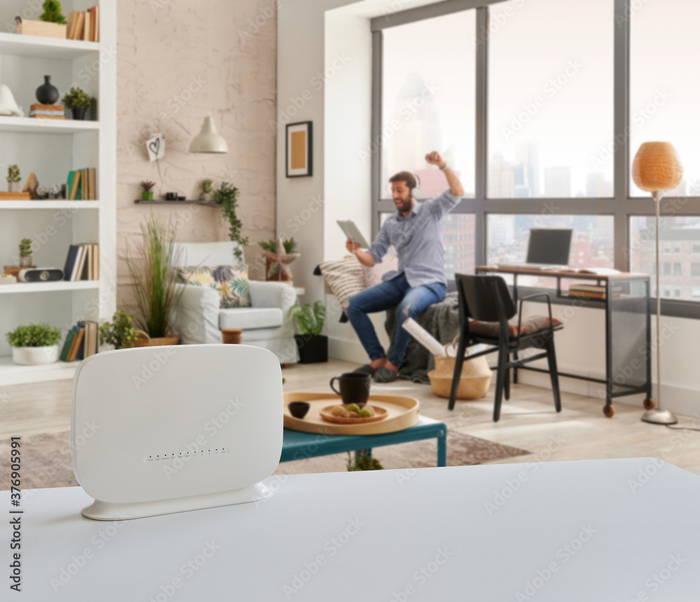 Router interior room on the table and man is accessing internet. Router interior room on the table and man is accessing internet.