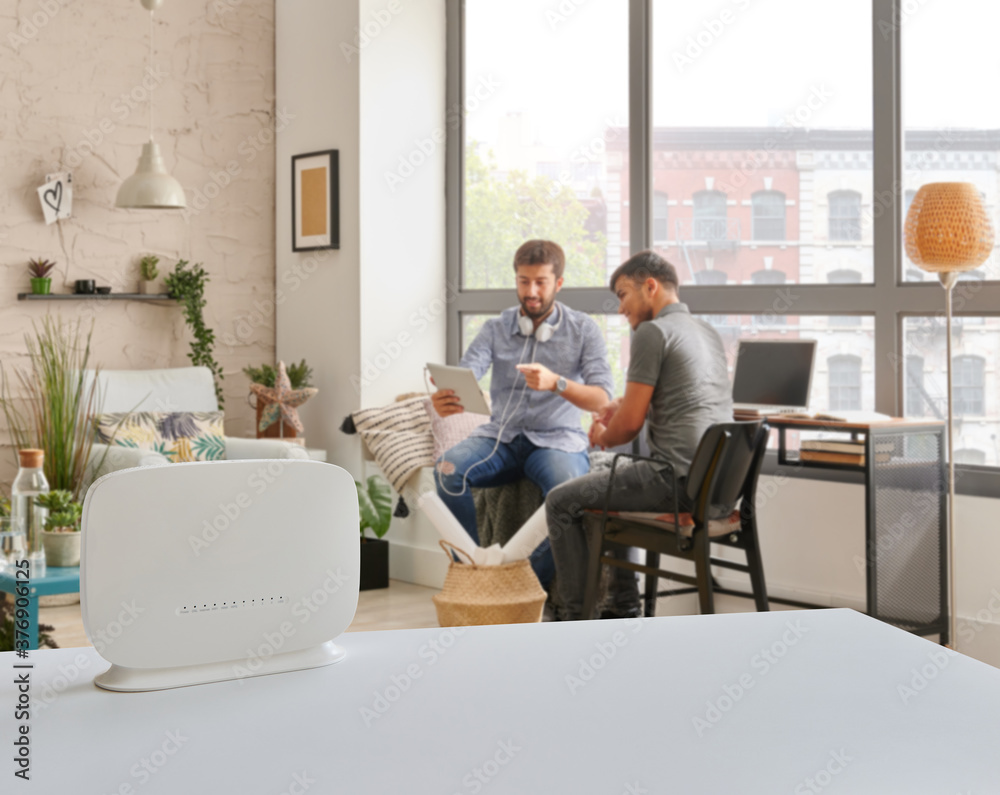 Router interior room on the table and two man is accessing internet. Router interior room on the table and two man is accessing internet.