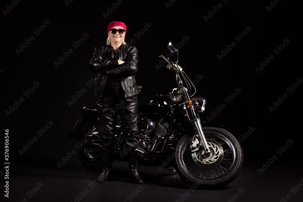 Full length body size view of her she nice attractive cheerful content grey-haired lady hipster rocker traveler chopper rider wearing leather clothes folded arms isolated black color background
