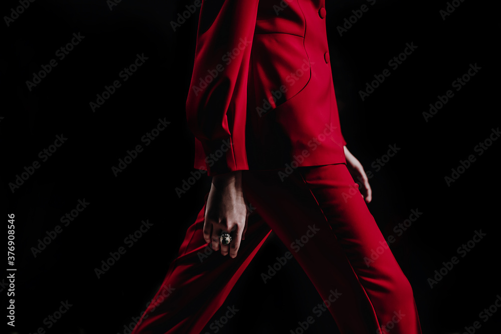 Cropped female fashion model in red stylish classy suit jacket and pants walking runway on the Fashion Show. Close up designer fashion details. Catwalk Fashion Week