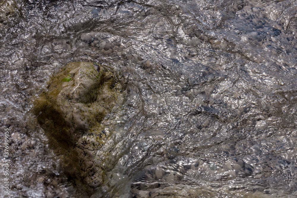 Naklejka premium Sea stones in the sea water. Pebbles under water. The view from the top. Nautical background. Clean sea water. Transparent sea.