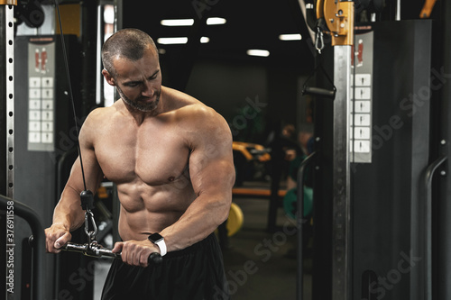 Muscular bodybuilder during his workout in the gym photo