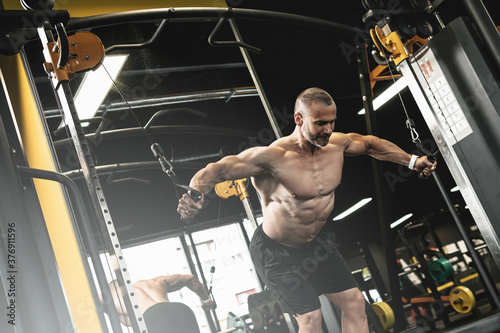 Fotografija Muscular bodybuilder during his workout in the gym