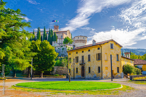 Castle of Brescia medieval building or Castello di Brescia or Falcon of Italy on Cidneo Hill with green park in historical city centre, blue cloudy sky background, Lombardy, Northern Italy photo
