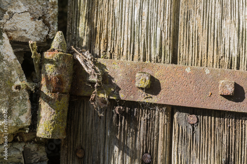 Canvas-taulu Detail of weathered iron hinge on the worn shutters of an abanoned building in France