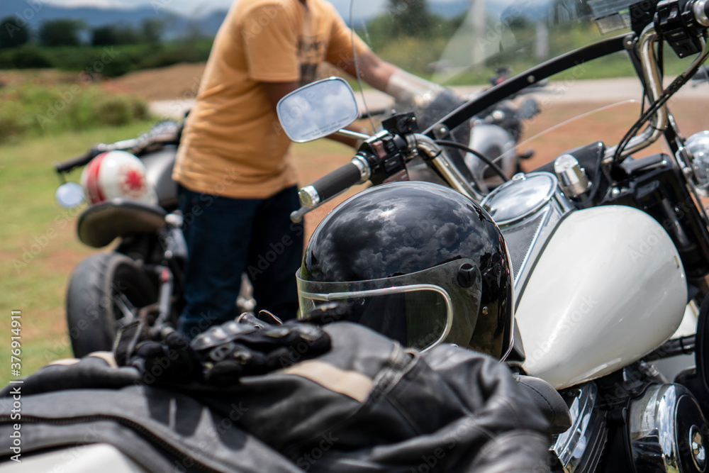 Motorbike parking and biker place helmet, Leather jacket and gloves on motorcycle. Young Traveller men ride motorcycle on highway, Thailand. Trip and lifestyle of motorbike concept.