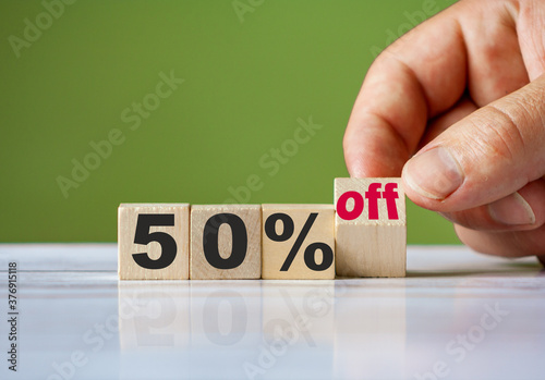 The hand turn wooden block and change word to 50% off. Sale background concept