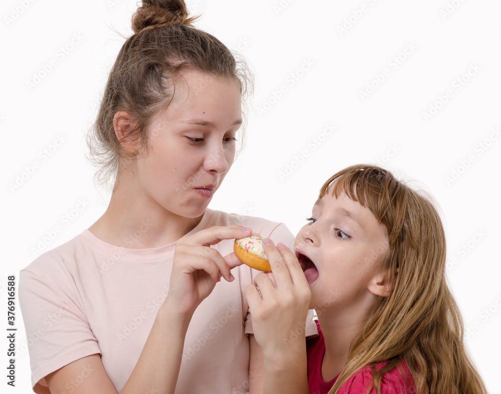 Two nice girls eat delicious sweet donut and smile Two nice girls eat delicious sweet donut and smile