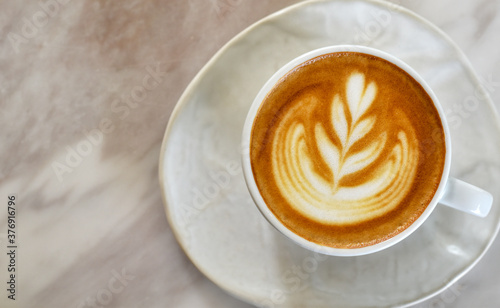 Texture of latte art, Top view white coffee cup on marble table.