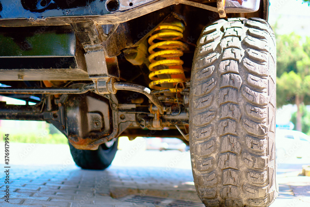 SUV transmission. Oversized off-road wheel tread. Yellow shock absorber spring.