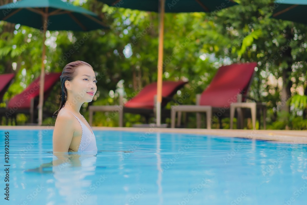 Portrait beautiful young asian woman enjoy relax smile leisure around outdoor swimming pool