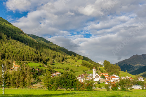 The mountain village of Curon (Graun) in Val Venosta, against a beautiful sky, on a sunny summer day, South Tyrol, Italy