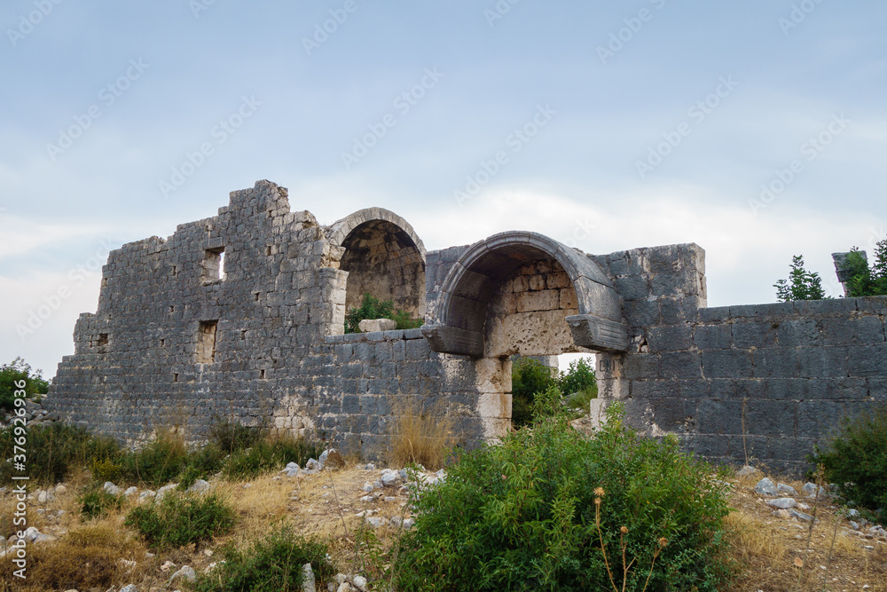 Damaged walls of church in ancient city Korikos, Kızkalesi, Turkey. Altar part of building is on background. City was important port of medieval Kingdom of Cilicia, abandoned after series of wars