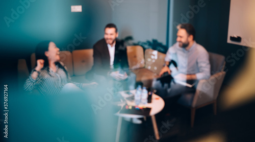 Group of cheerful colleagues having break in office recreation area