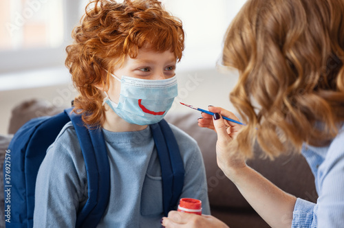 Mother draws a smile on the son's protective mask photo