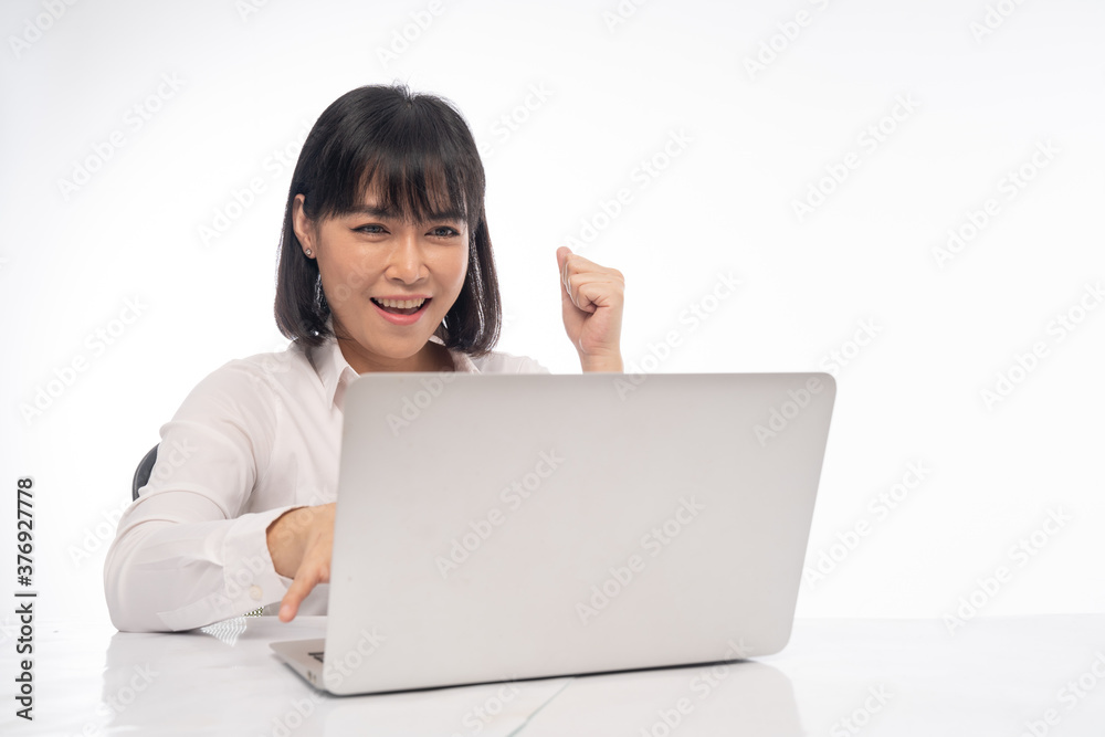 An office lady showing a happy expression on her desk has a labtob An office lady showing a happy expression on her desk has a labtob